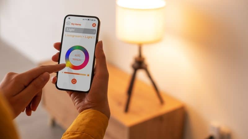 controlando a iluminação inteligente em casa, ela está definindo a cor da luz usando seu smartphone